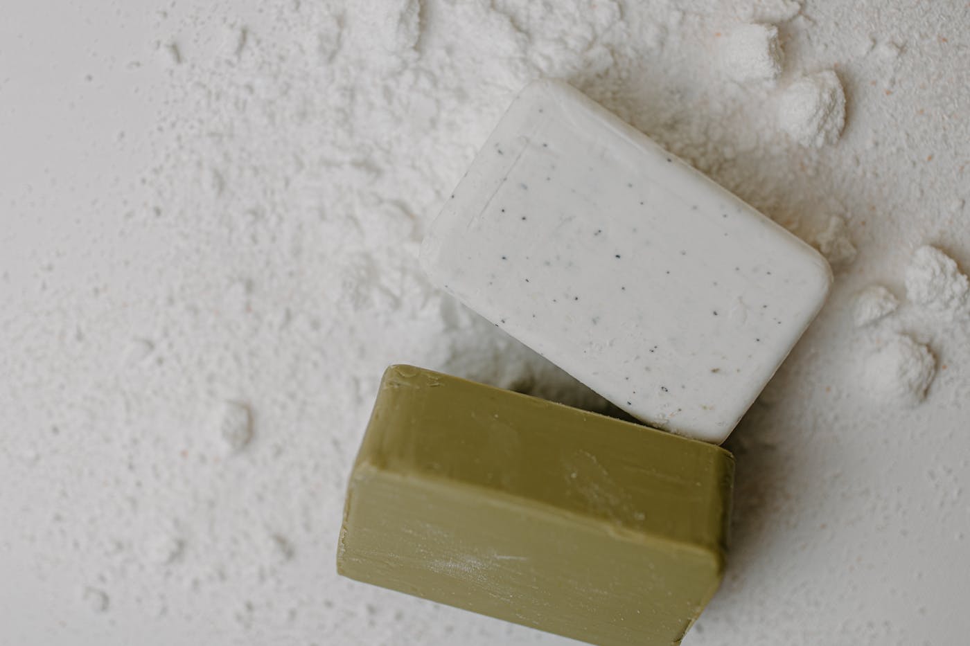 Handmade soap bars stacked on a clean white surface, ready for an apothecary shelf.